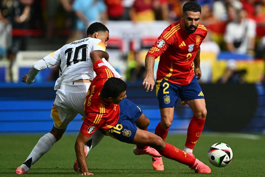 Dani Carvajal (R) en Rodri, in duel met Jamal Musiala.