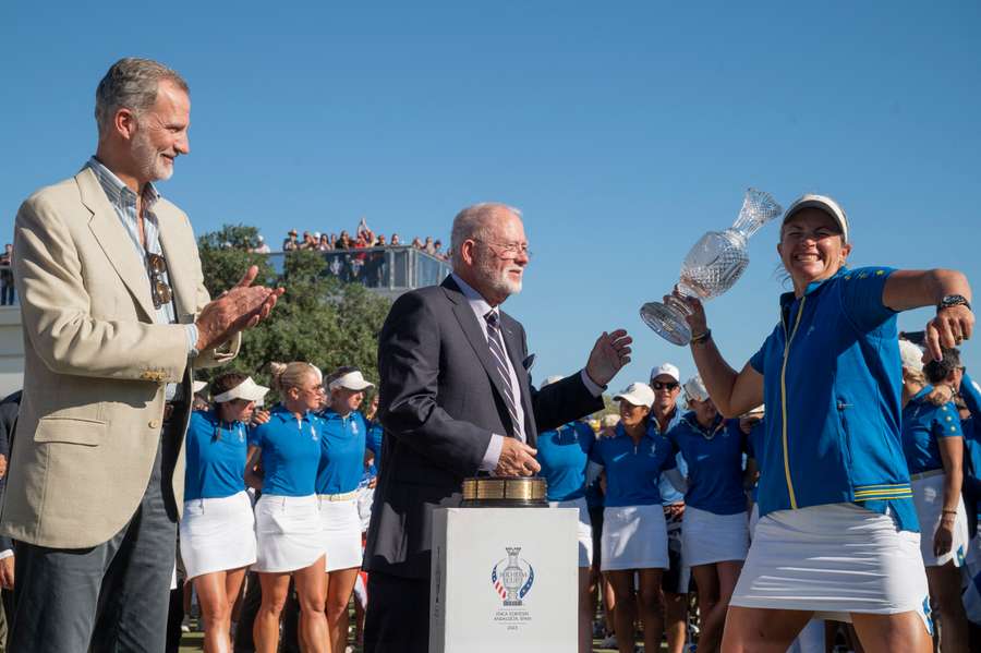 King Felipe VI of Spain, left, claps as team Europe's captain Suzann Pettersen lifts the trophy to celebrate retaining the Solheim Cup