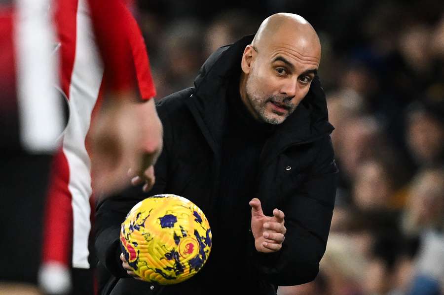 Pep Guardiola catches the ball during the English Premier League football match between Manchester City and Brentford