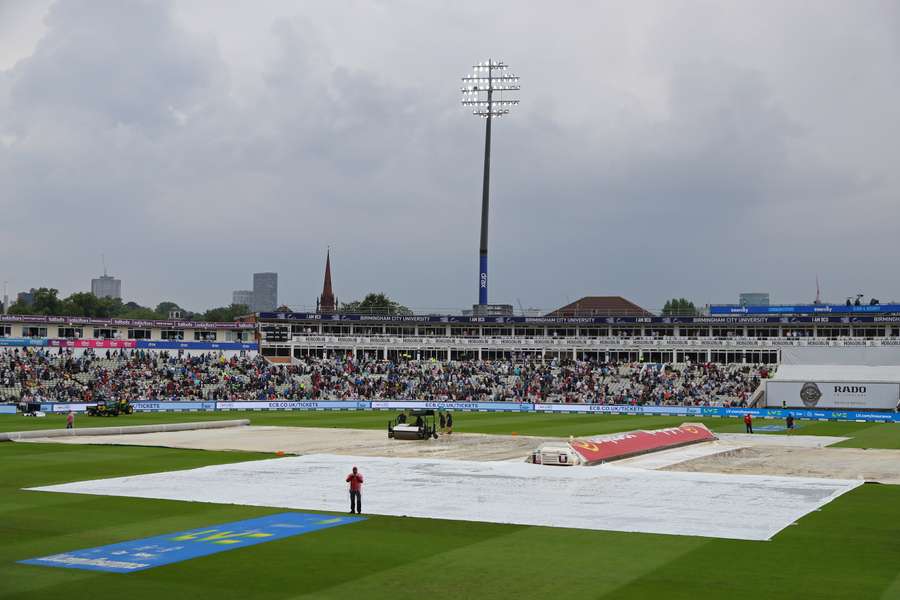 The covers and the floodlights are on as rain stops play on day three of the first Ashes cricket Test match