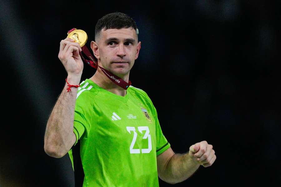 Emiliano Martínez ukazuje medailu, pod ktorú sa svojimi výkonmi výrazne podpísal.