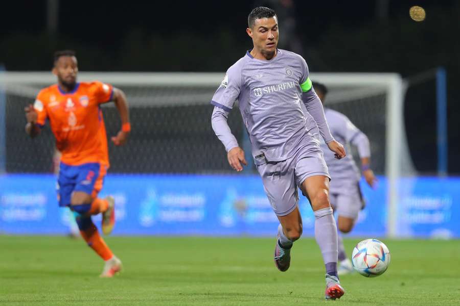 Cristiano Ronaldo runs with the ball during the Saudi Pro League football match between Al-Fayha and Al-Nassr