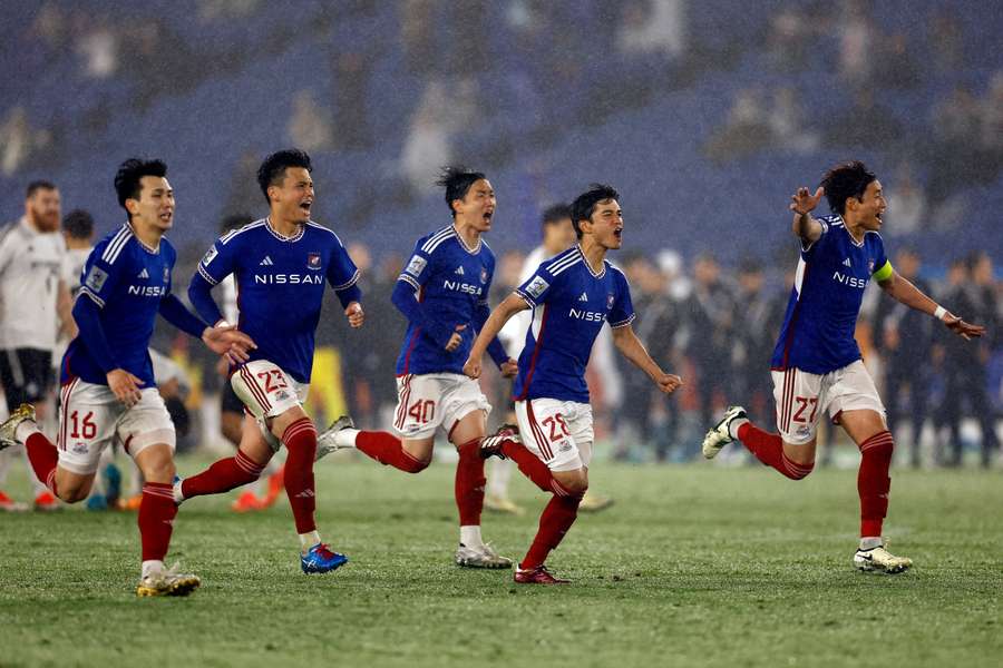 Yokohama F Marinos players celebrate winning the penalty shootout to qualify for the finals