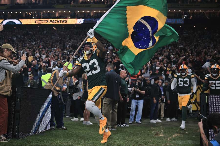 Evan Williams, do Green Bay Packers, entra em campo com a bandeira do Brasil