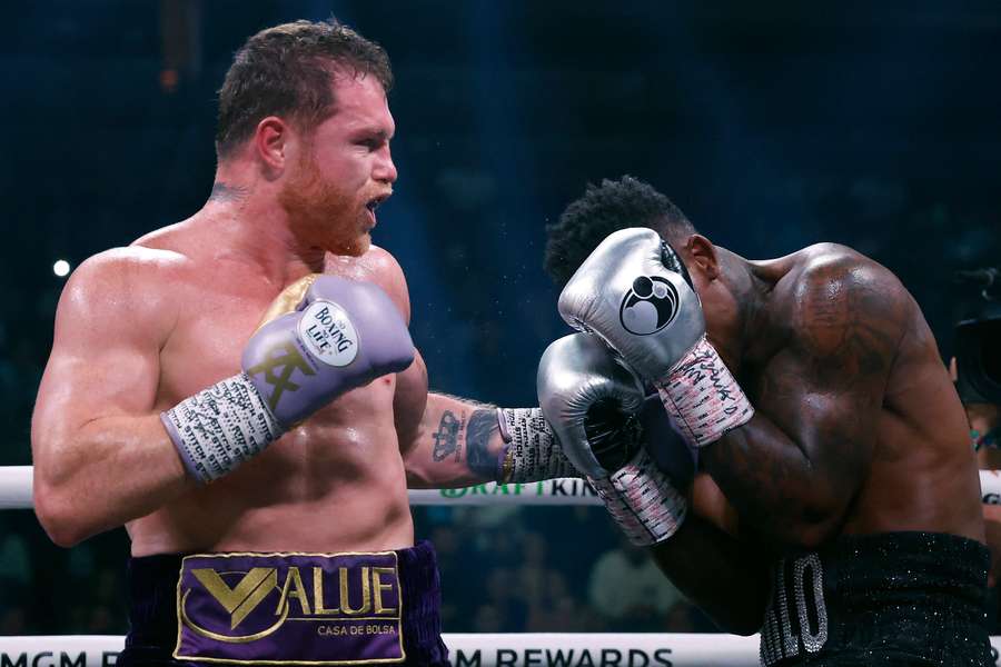 Alvarez (L) takes a swing at Charlo