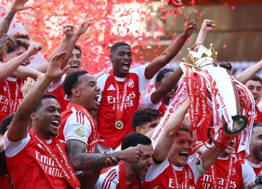 Arsenal's Martin Odegaard lifts the trophy as he celebrates with teammates after winning the Premier League
