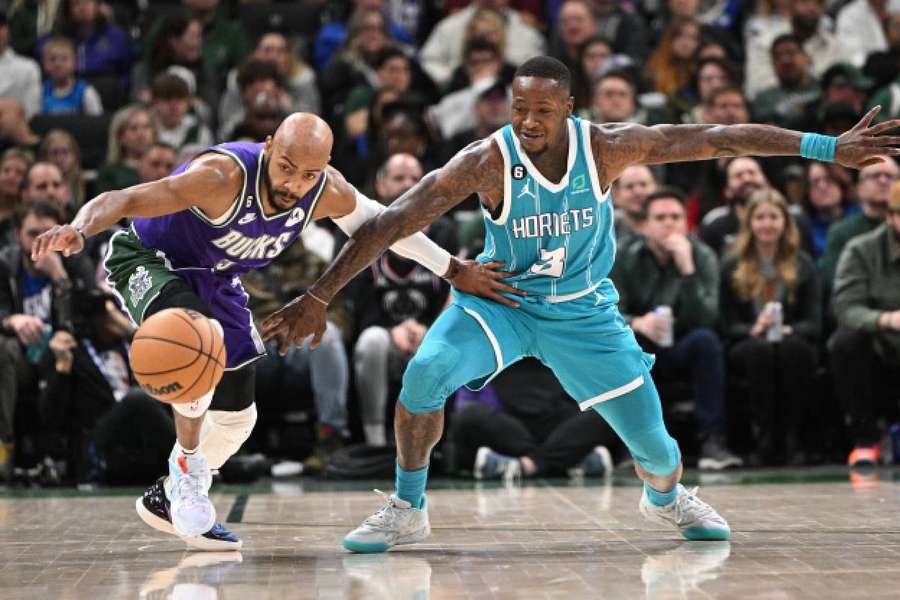 Milwaukee Bucks guard Jevon Carter and Charlotte Hornets guard Terry Rozier battle for a loose ball