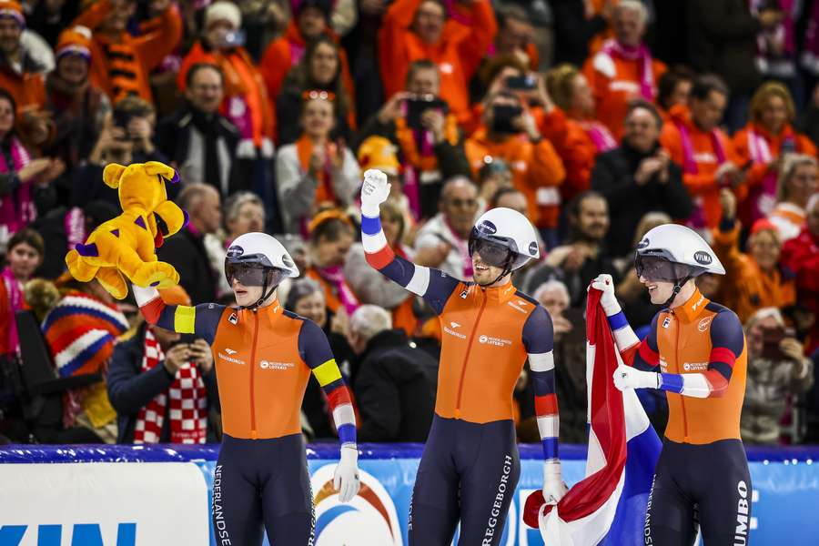 Marcel Bosker, Patrick Roest en Beau Snellink juichen na het winnen van de ploegenachtervolging voor mannen op de WK Afstanden schaatsen in Thialf