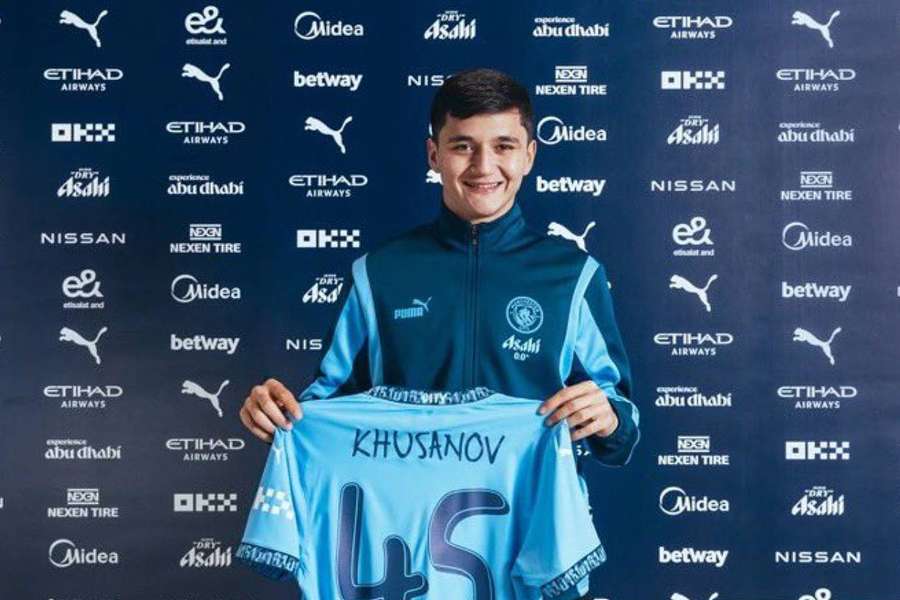 Khusanov posando con su nueva camiseta.