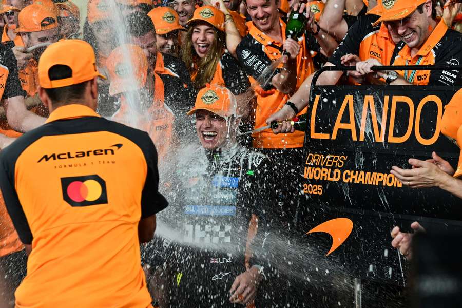 World champion and race third-placed McLaren's British driver Lando Norris (C) celebrates with his team