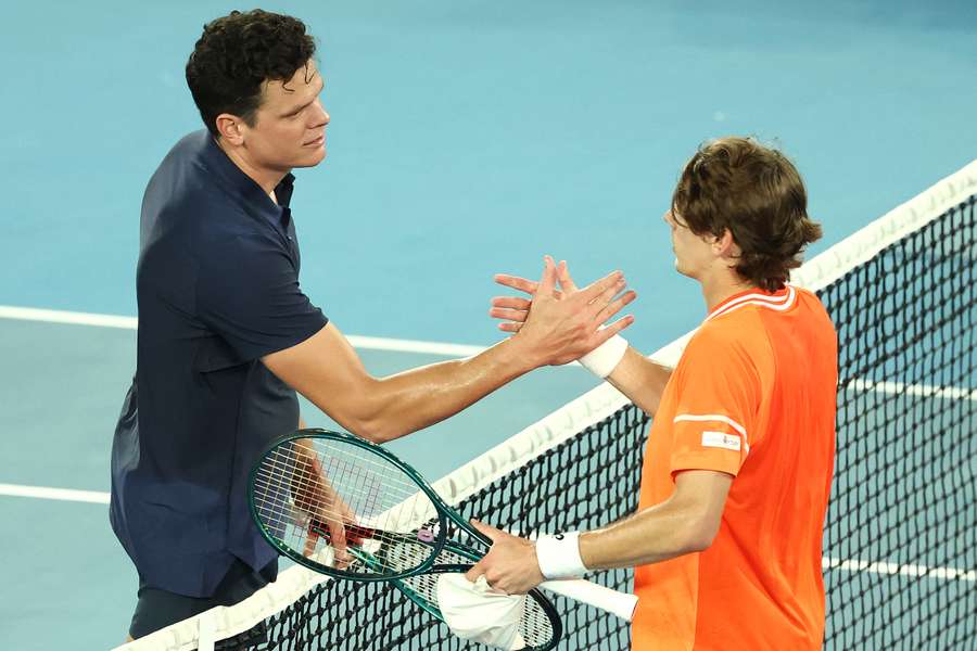 Australia's Alex De Minaur (R) shakes hands with Canada's Milos Raonic