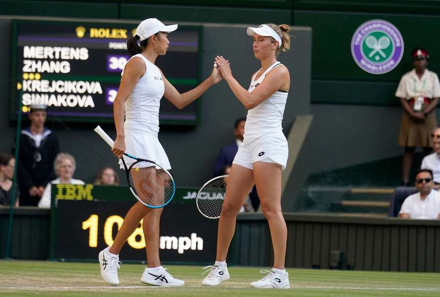 Elise Mertens din Belgia și Zhang Shuai din China sărbătoresc un punct în finala probei feminine de dublu de la Wimbledon 2022.