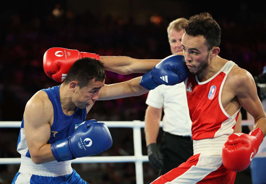 Hasanboy Dusmatov of Uzbekistan in action against Billal Bennama of France