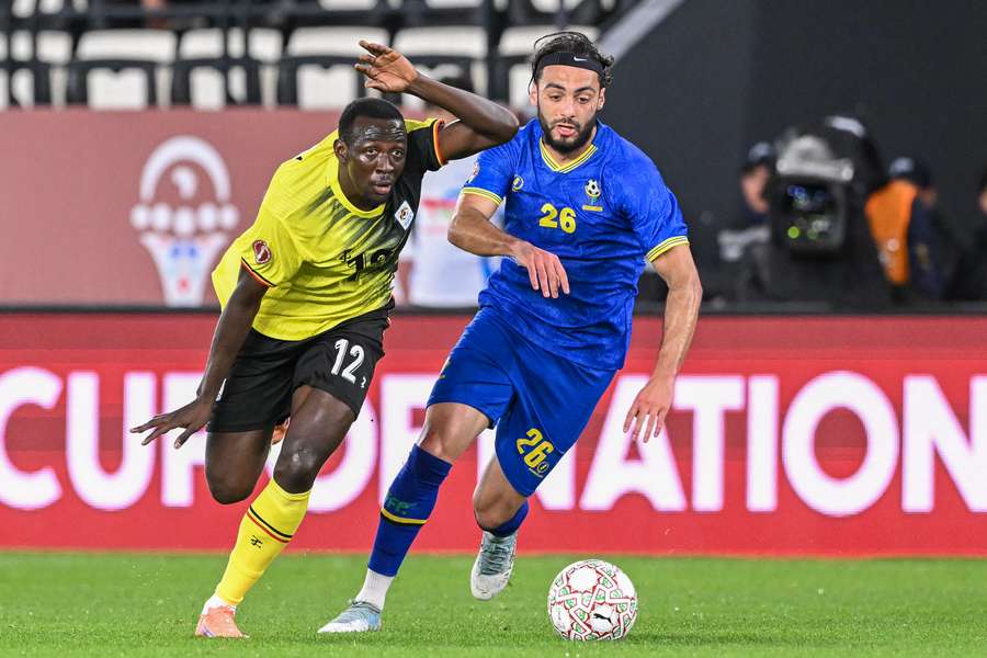 Uganda's Baba Alhassan, left, and Tanzania's Tarryn Allarakhia vie for the ball