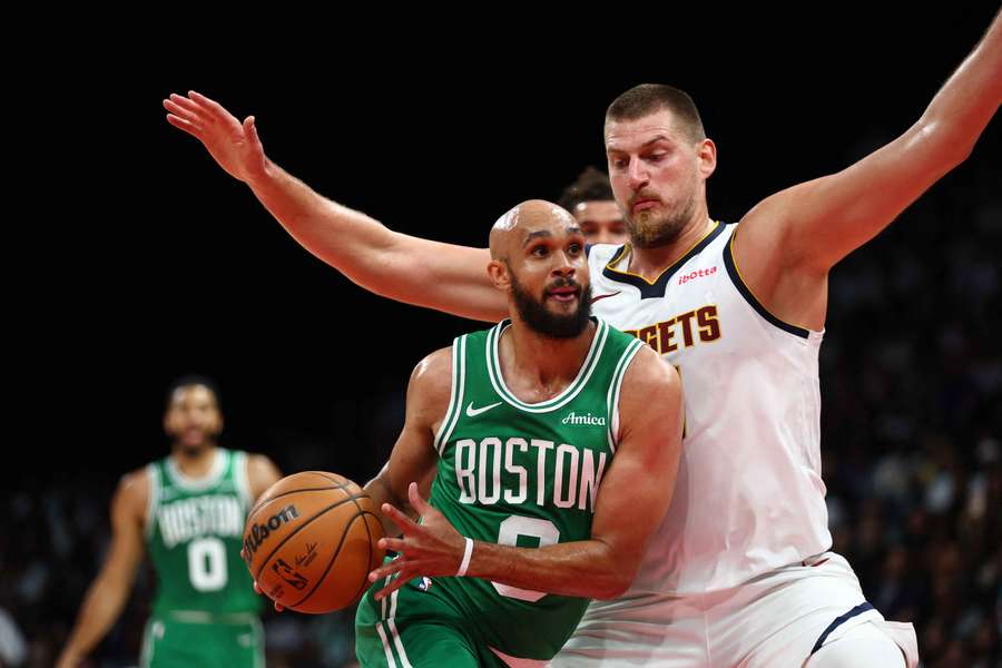 Derick White of the Boston Celtics drives against Nikola Jokic of the Denver Nuggets during the match