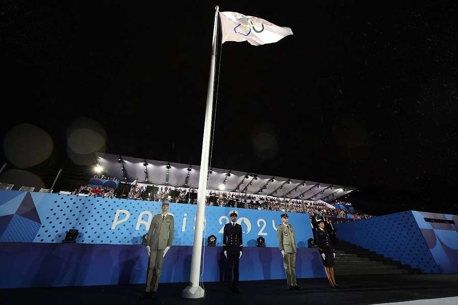 Le drapeau olympique hissé en face de la tour Eiffel