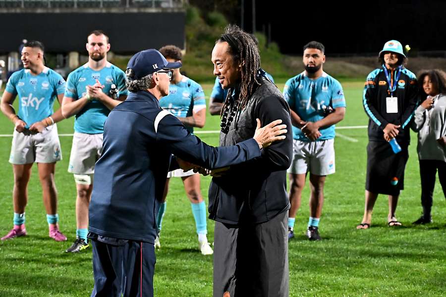 Moana Pasifika head coach Tana Umaga is embraced by Reds head coach Les Kiss. Moana Pasifika head coach Tana Umaga is embraced by Reds head coach Les Kiss.