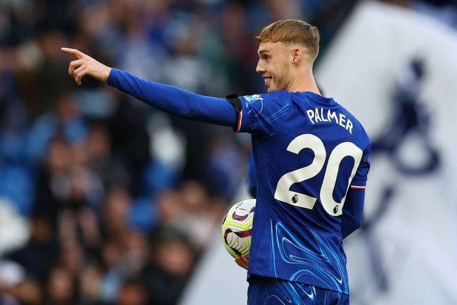 Chelsea's Cole Palmer celebrates as he holds the match ball after scoring four goals against Brighton