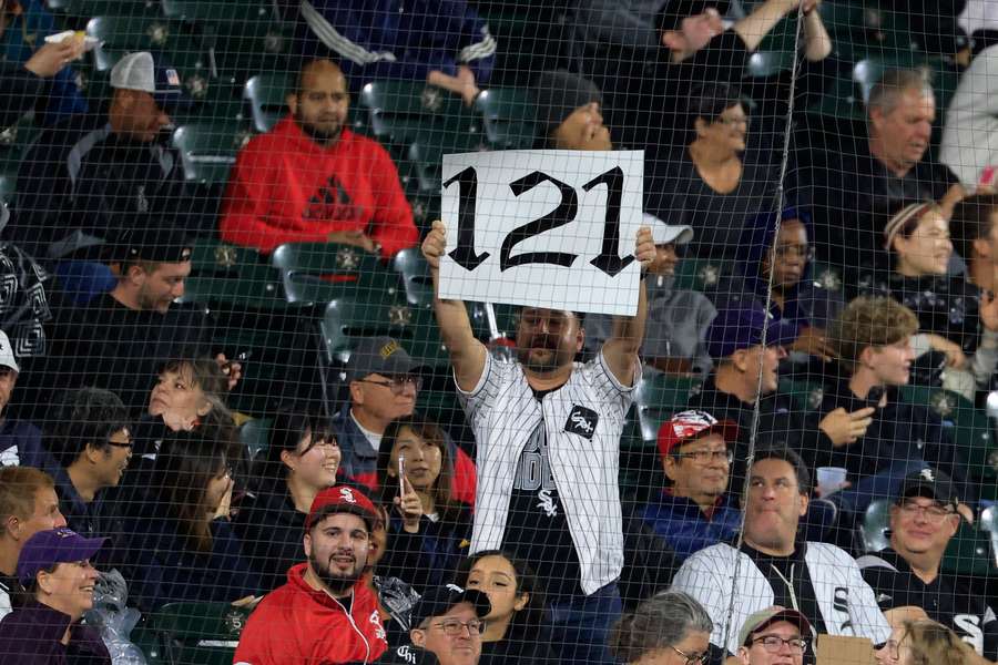 A Chicago White Sox fan holds up a sign after the team's 121st loss of the Major League Baseball season