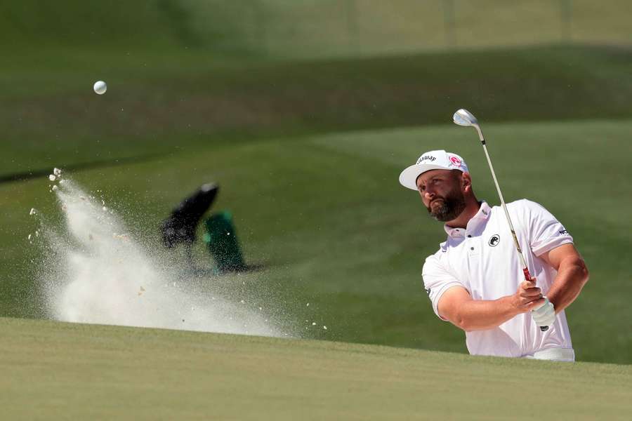 Jon Rahm hits out of a bunker on the seventh hole at the Masters
