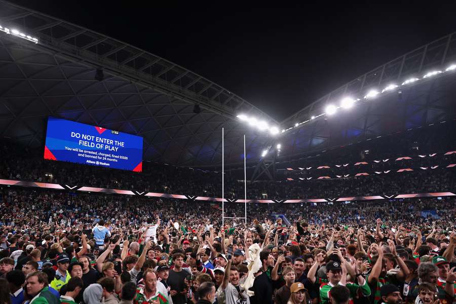 Fans storm the Allianz Stadium pitch to celebrate AJ's record-breaking feat.