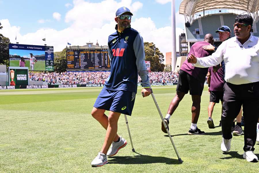 Nathan Lyon hobbles on crutches after injuring his hamstring in Adelaide on Sunday.