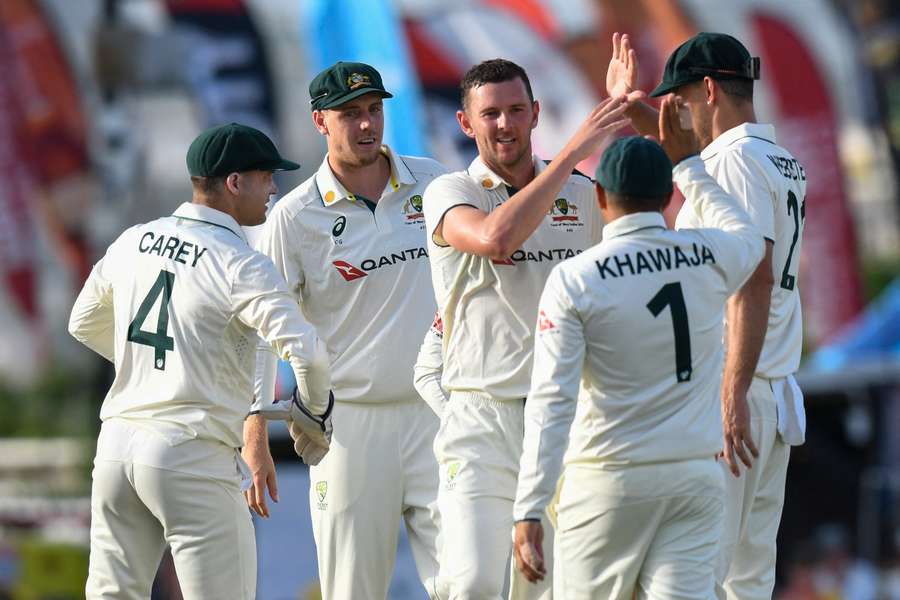 Josh Hazlewood (second left) and Beau Webster (left) of Australia celebrate the dismissal of Jomel Warrican of the West Indies