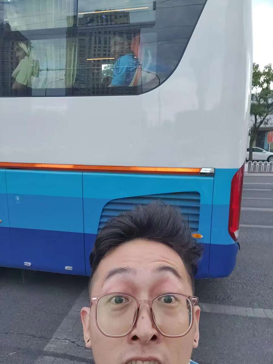 Liu Yuhang poses for a selfie as Argentine football player Lionel Messi is seen riding a team bus enroute to a training session in Beijing