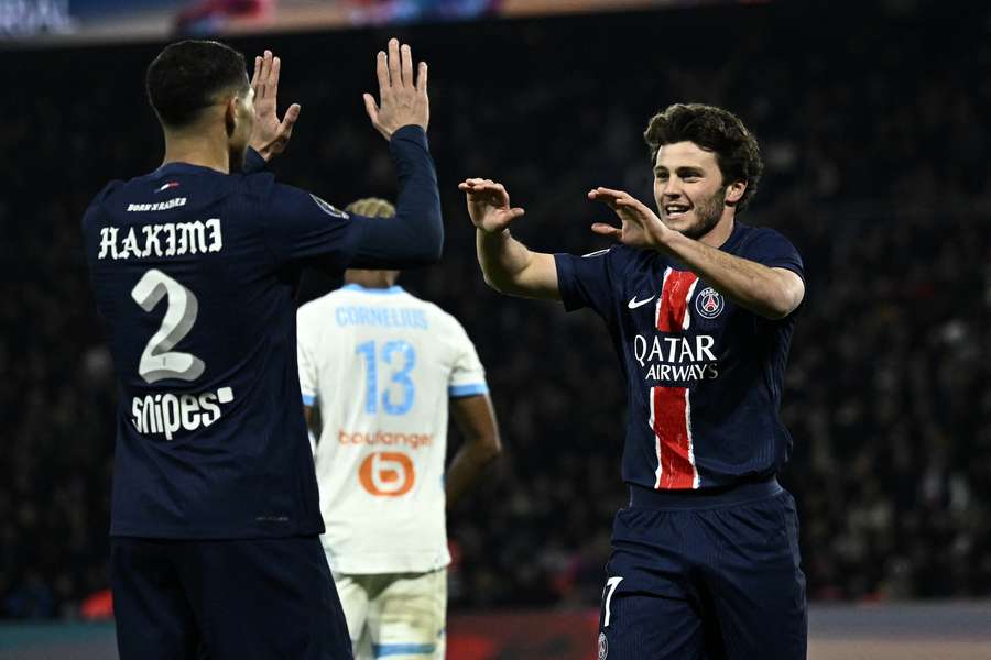 Paris Saint-Germain's Portuguese midfielder #87 Joao Neves (R) and Moroccan defender #02 Achraf Hakimi celebrate their team's third goal 