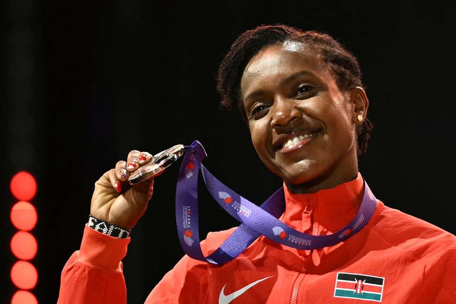 Kipyegon celebrates on the podium for the women's 5000m final during the World Athletics Championships in Tokyo