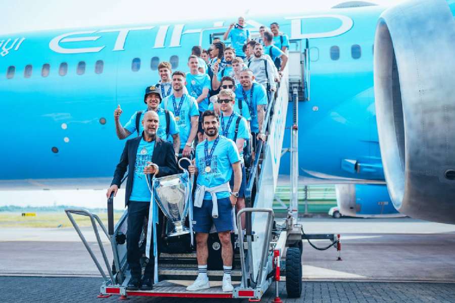 Guardiola e os jogadores do City no desembarque a Manchester