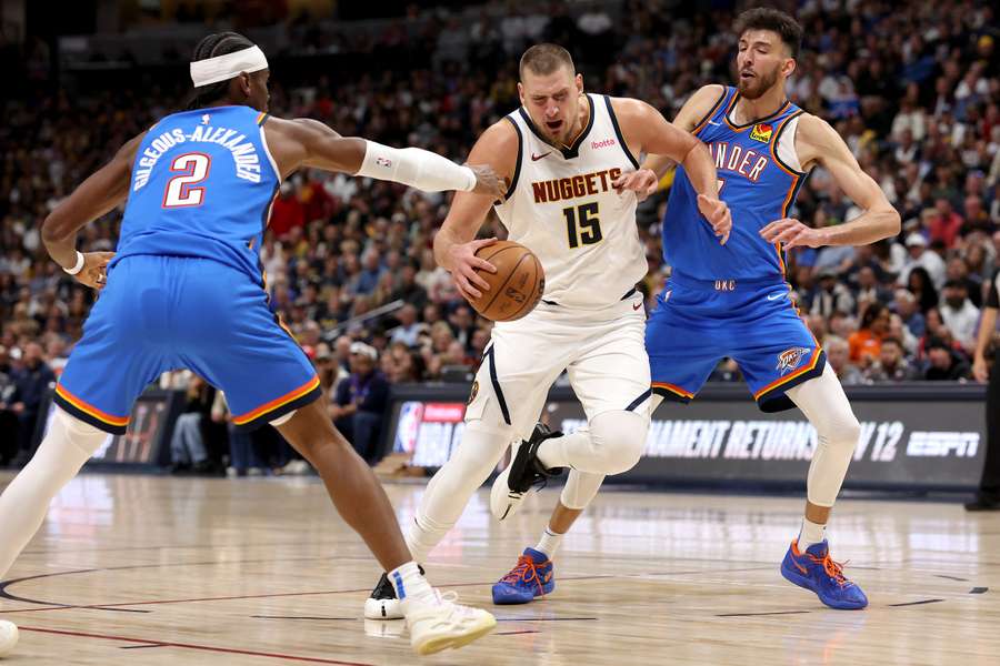 Denvers Nikola Jokic in actie tegen Oklahoma City's Shai Gilgeous-Alexander en Chet Holmgren