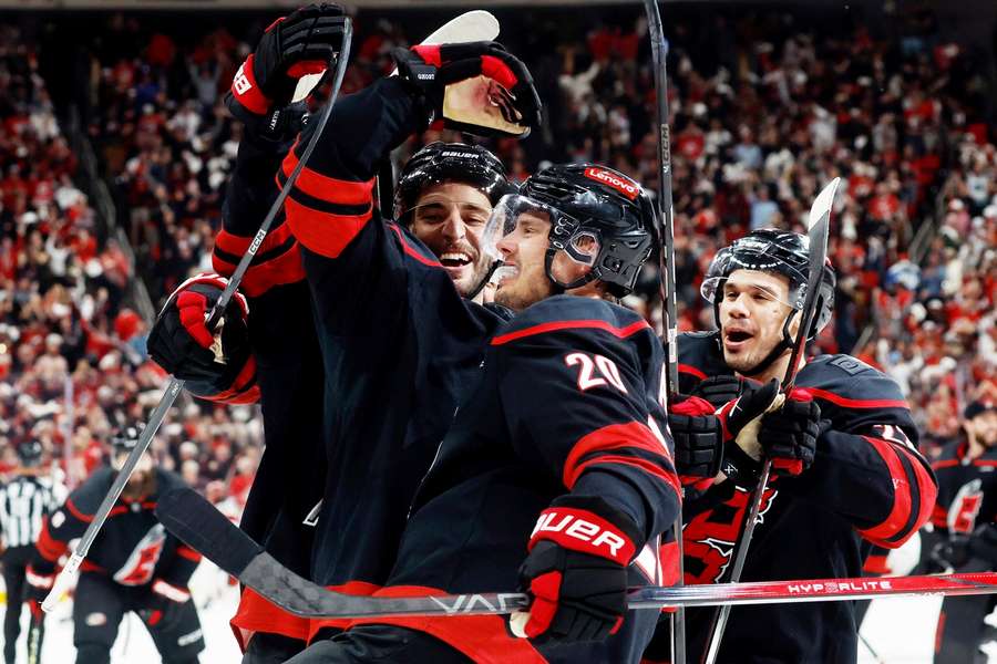 Hráči Caroliny oslavují postup. Zleva Shayne Gostisbehere, Sebastian Aho a Logan Stankoven.