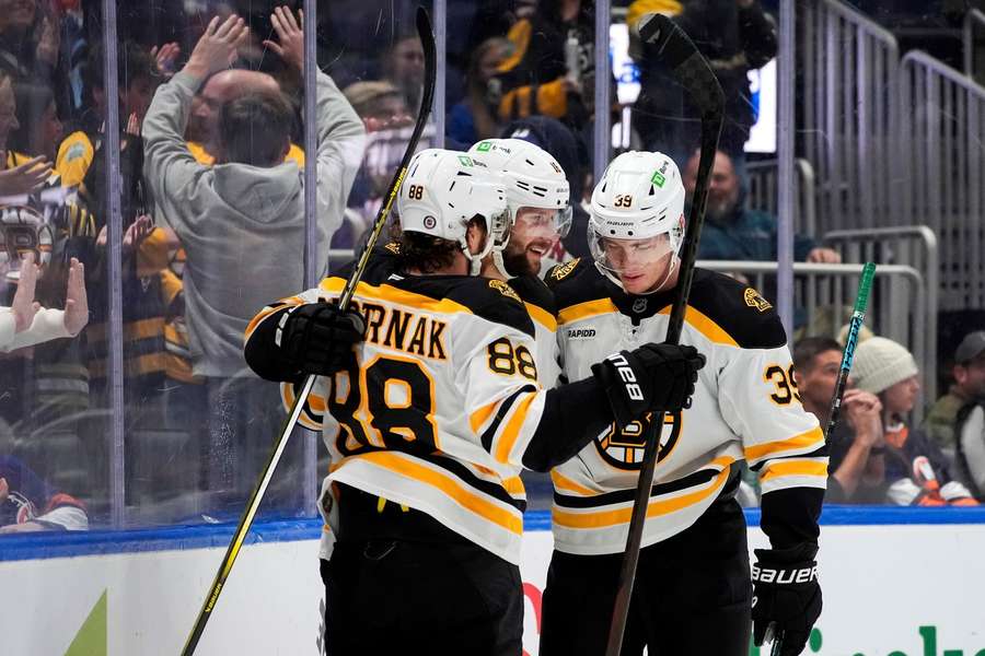 Pastrňák a Zacha se radují z gólu do sítě New York Islanders.