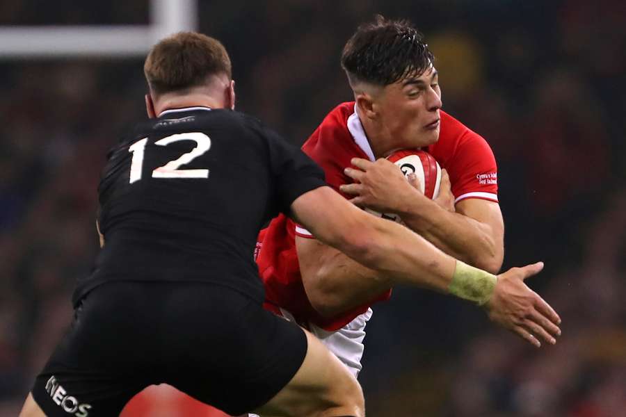 Rees-Zammit (R) runs with the ball in Wales' match against New Zealand