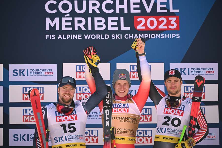 Second-placed Aleksander Aamodt Kilde (L), first-placed Switzerland's Marco Odermatt (C) and third-placed Cameron Alexander (R) celebrate on the podium