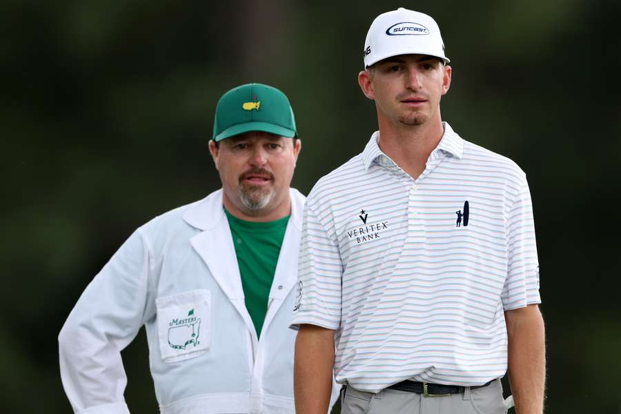 Sam Bennett talks with his caddie on the 18th green