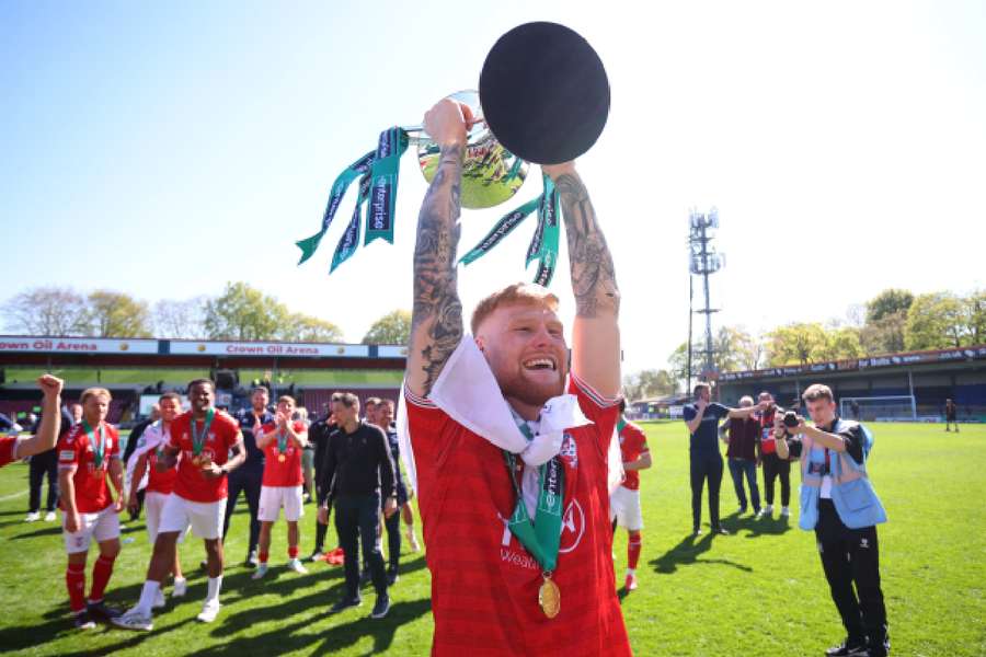 York City's Josh Stones celebrates with the National League trophy after winning promotion to EFL League Two