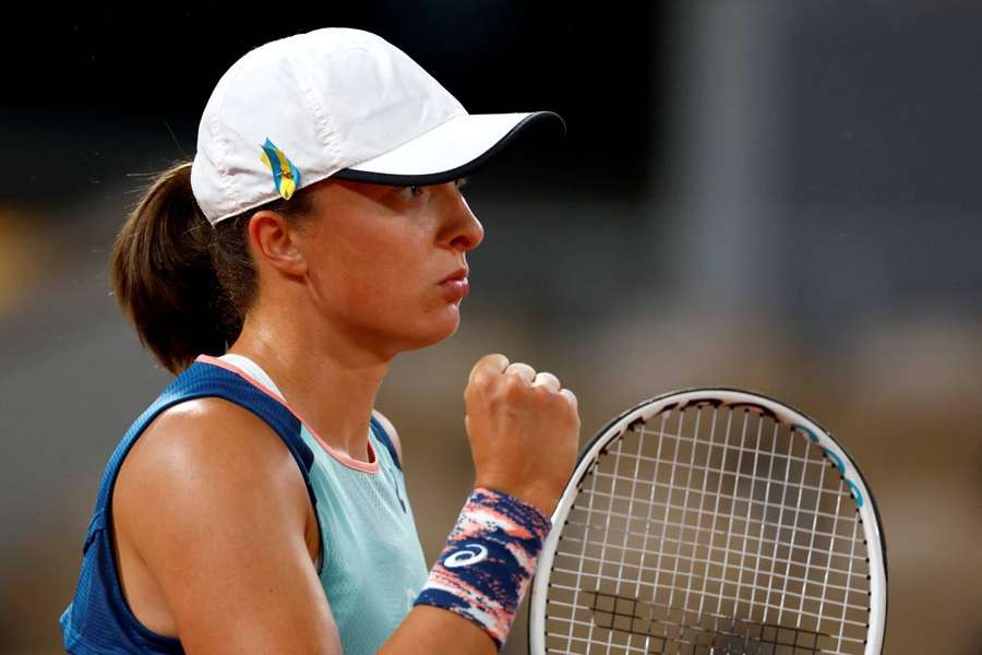 Swiatek wears a Ukrainian flag on her cap during matches