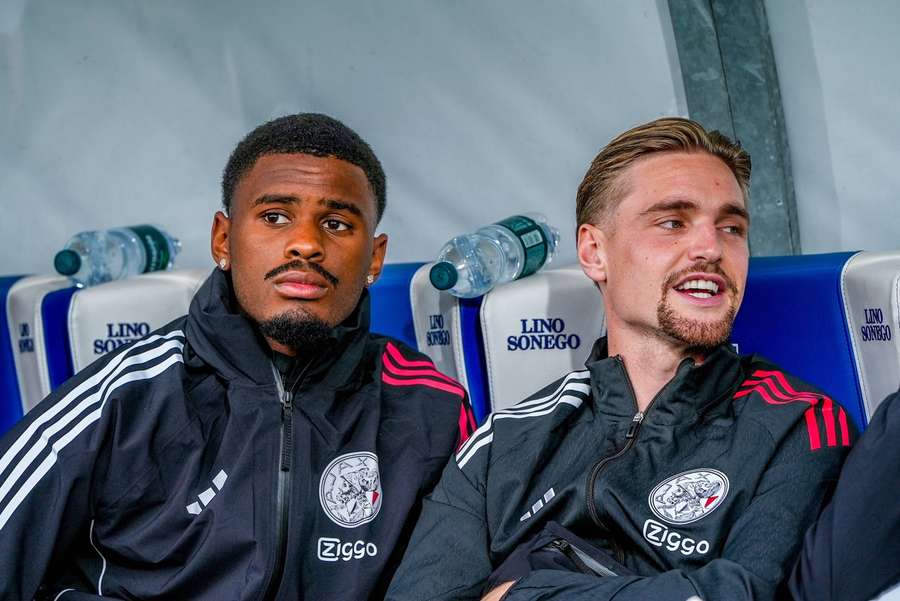 Jorrel Hato (L) and Kenneth Taylor on the bench during Ajax's preseason match against Como