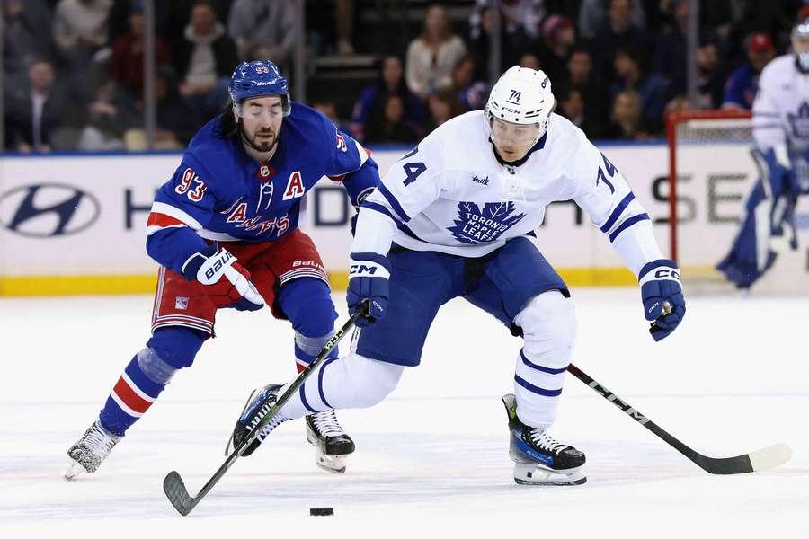 Maple Leafs' Bobby McMann (right) fighting for the puck against Rangers' Mika Zibanejad (left)