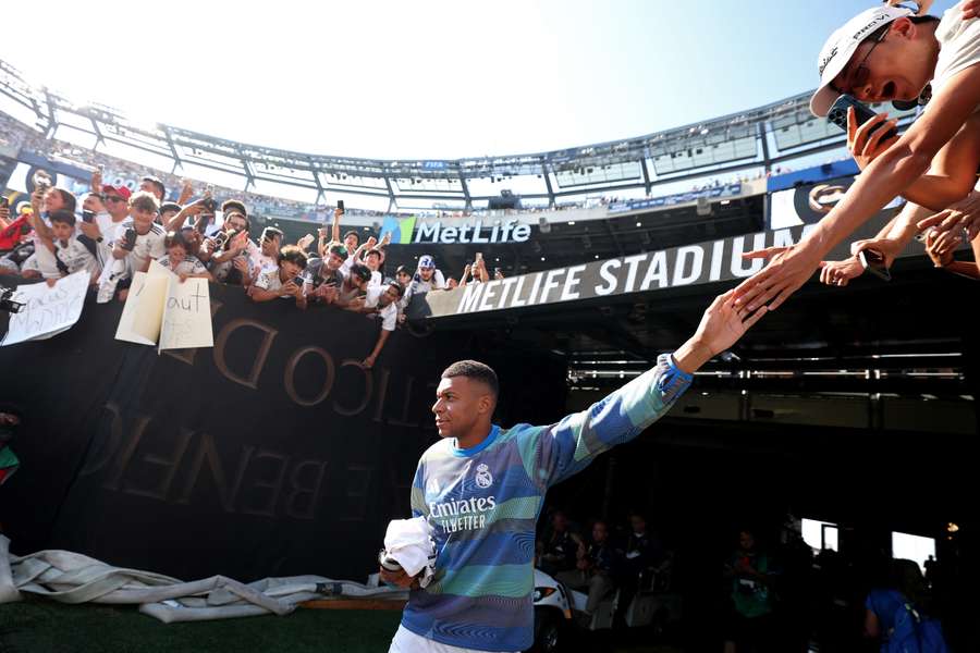 Real Madrid's French forward #09 Kylian Mbappe (C) greets supporters