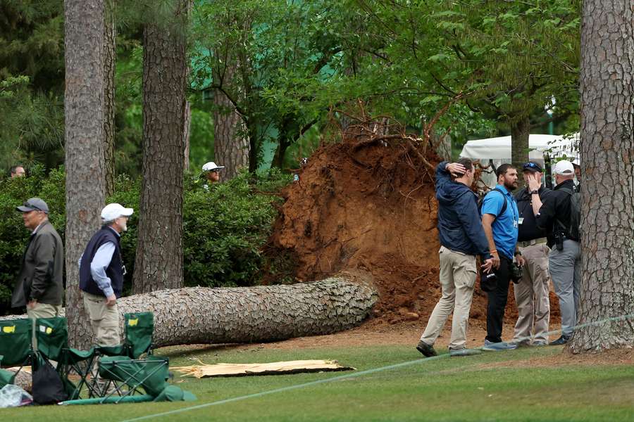 Course officials look over fallen trees on the 17th tee during the second round of the 2023 Masters Tournament at Augusta