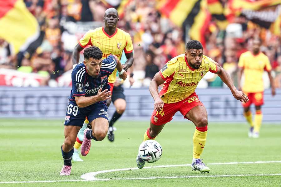 Lyon's Georges Mikautadze fights for the ball with Lens' Matthieu Udol