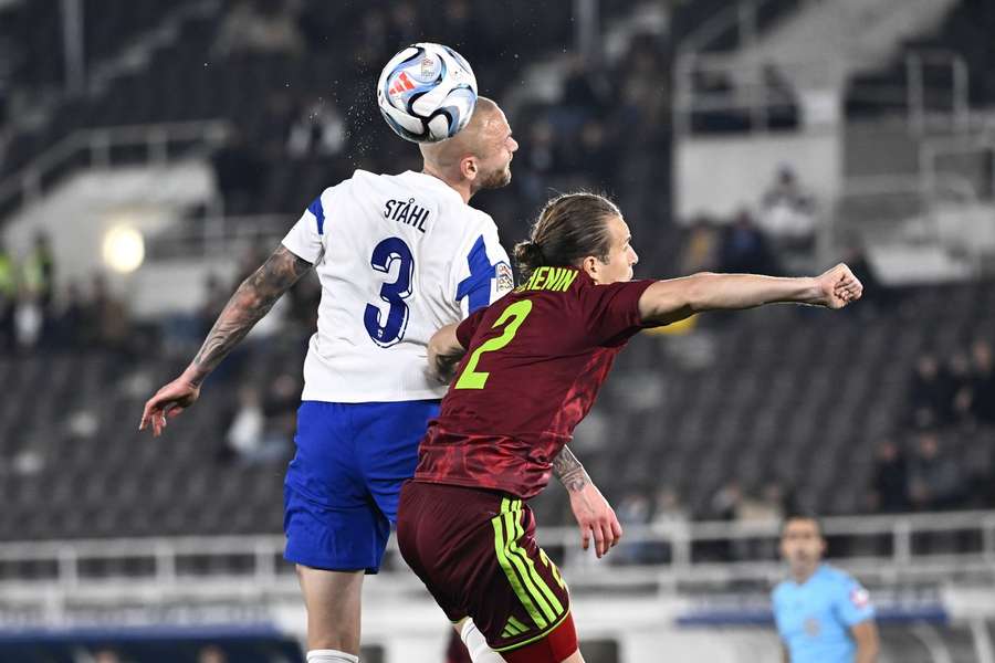 Adam Stahl of Finland wins a header against Kirill Pechenin of Belarus