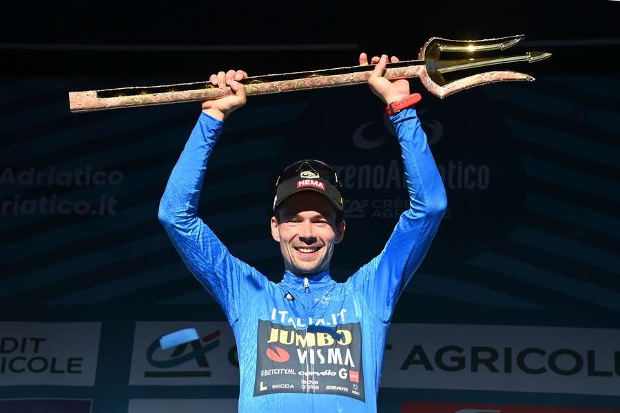 Slovenian rider Primoz Roglic of the team Jumbo-Visma celebrates on the podium with the overall leader jersey