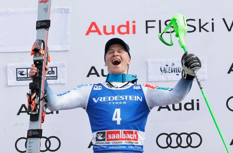 Timon Haugan celebrates on the podium after winning the slalom