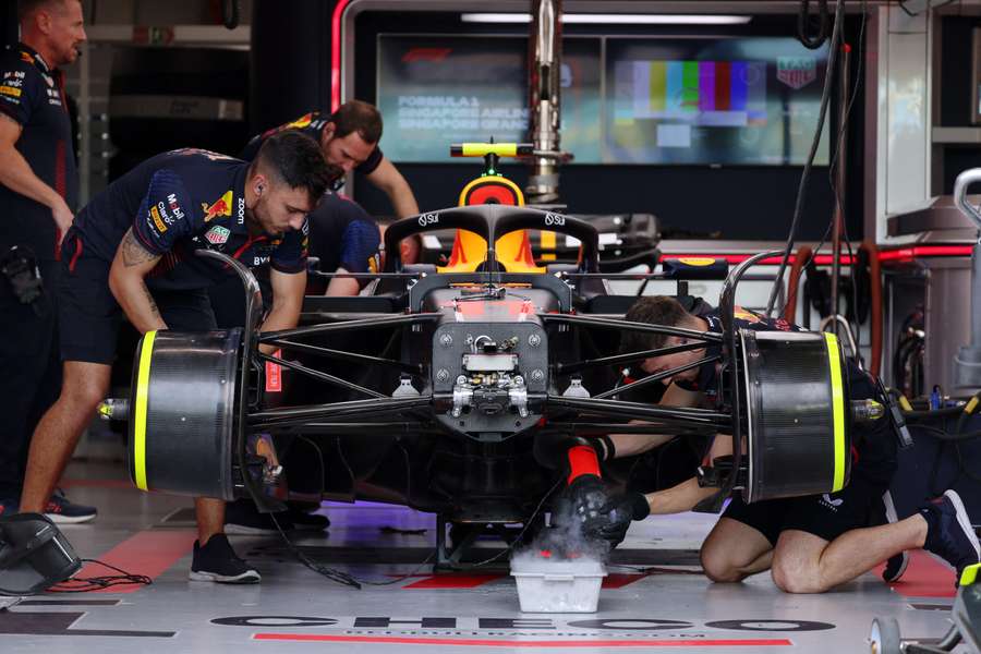 Os mecânicos trabalham no carro de Sergio Perez, da Red Bull, na garagem antes dos treinos