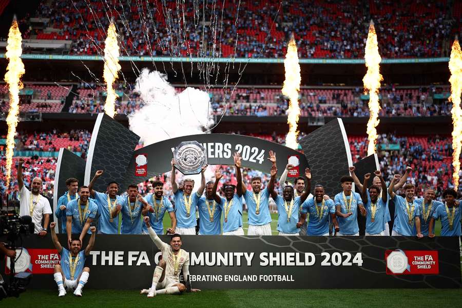 Manchester City players celebrate with the trophy