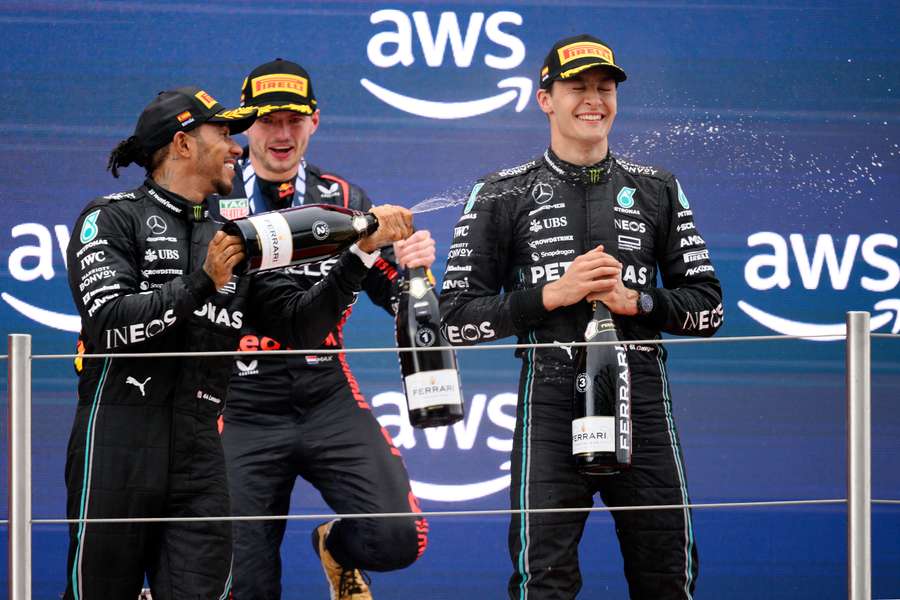 Mercedes driver Lewis Hamilton (L), Red Bull driver Max Verstappen (C) and Mercedes driver George Russell celebrate on the podium